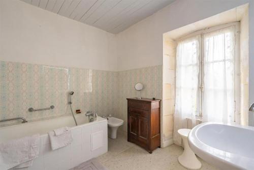 Un baño con bañera, inodoro y lavabo. en Chambres et table d'hôtes Maison Garesché, en Nieulle-sur-Seudre