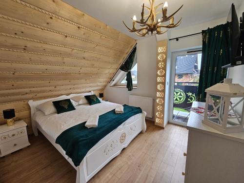 Un dormitorio con una cama y una pared de madera. en Apartament Parzenica przy Termach Chochołowskich, en Witów