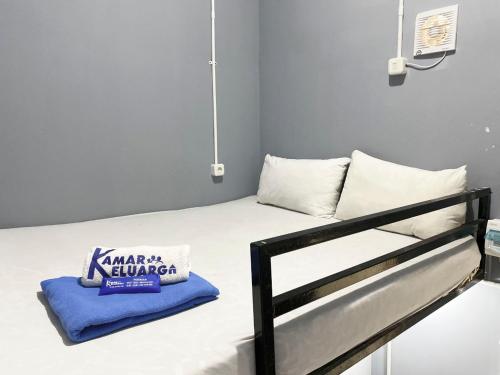 a bedroom with a bed with a pillow on it at Helloroom Mampang Jl Bank in Jakarta