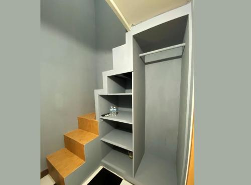 a staircase in a room with wooden shelves at Helloroom Mampang Jl Bank in Jakarta