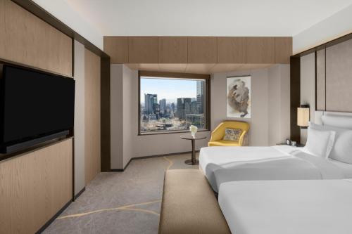 a hotel room with a bed and a large window at ANA InterContinental Tokyo by IHG in Tokyo