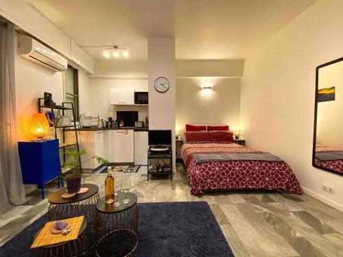 une chambre avec un grand lit et une cuisine dans l'établissement Cosy studio à 2 pas de la mer, à Nice