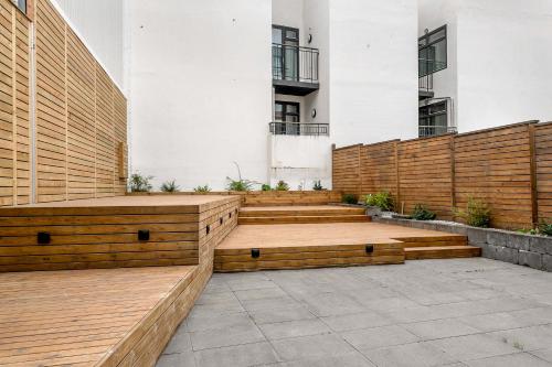 a patio with wooden benches in front of a building at The Swan House by Heimaleiga in Reykjavík