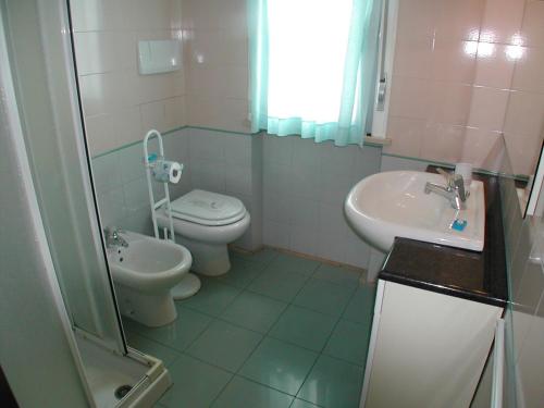 La salle de bains est pourvue de toilettes et d'un lavabo. dans l'établissement Residence Mediterraneo, à San Benedetto del Tronto