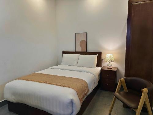 a bedroom with a large bed and a chair at Amelia House - Boutique Hotel in Khu Chi Lăng