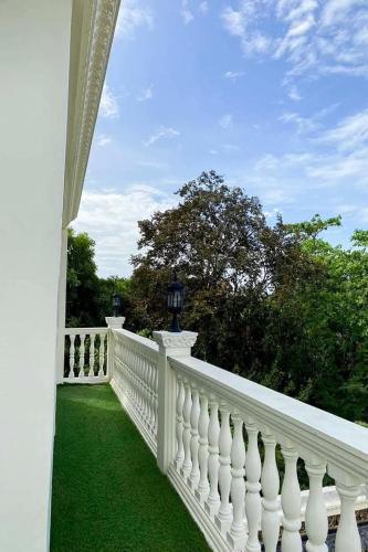 a white fence on a yard with green grass at Sibsib Baybayin Beach Resort in Tanza