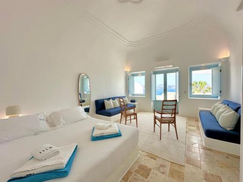 a bedroom with a large bed and a living room at Ilia Oia in Oia