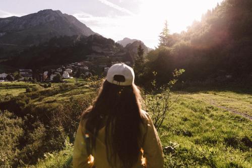 a woman standing on a hill looking at the mountains at Après Post Hotel in Stuben am Arlberg