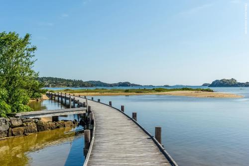 a wooden bridge over a body of water at Åros Seaside Apartment with Pool, Jacuzzi & Sauna in Kristiansand