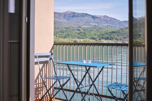 a table and chairs on a balcony with a view of the water at Hotel Carillon in Baveno