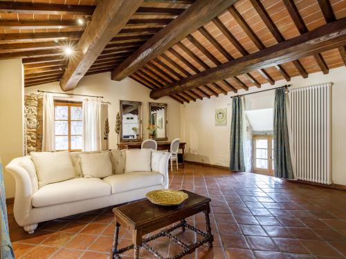a living room with a white couch and a table at Relais La Costa Historical Residence in Monteriggioni
