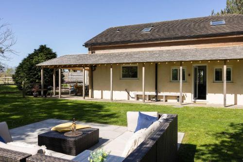 a house with a couch in front of a yard at Lux Countryside Haven Mins to Beach Garden in Birdham
