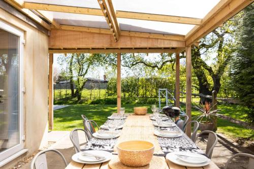 a long wooden table with chairs on a patio at Lux Countryside Haven Mins to Beach Garden in Birdham