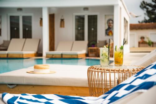 a pool with a table with a hat and drinks on it at Cavomarina Beach- Adults Only in Kavos