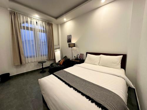 a bedroom with a large white bed and a window at Amelia House - Boutique Hotel in Khu Chi Lăng