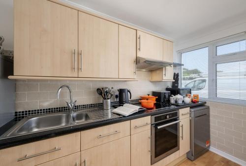 a kitchen with wooden cabinets and a sink at 3 Europa Court in Mawgan Porth in Mawgan Porth
