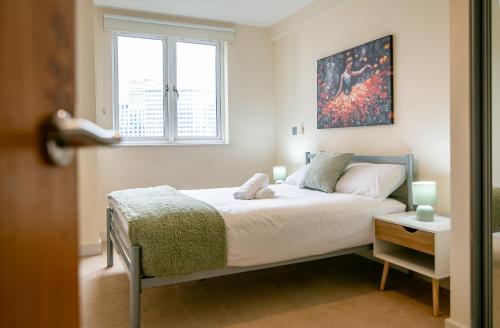 a bedroom with a bed and a window at Two-bed Luxury Apartment B12LS by LiveComfortably in Birmingham