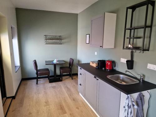 a kitchen with a sink and a table with chairs at Die Meid in Sint Maartensdijk