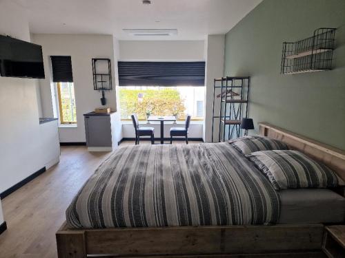 a bedroom with a large bed and a table with chairs at Die Meid in Sint Maartensdijk