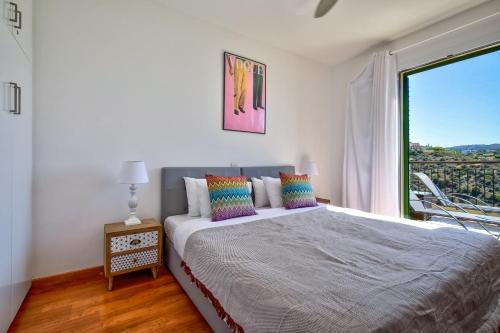 クークリアにあるModern Apartment U6 with Beautiful Sea Views, Aphrodite Hillsのベッドと大きな窓のある寝室