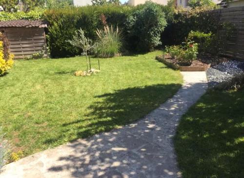 a garden with a walkway in the grass at Chambre et Sdb privées dans pavillon à 15 mn Orly in Savigny-sur-Orge