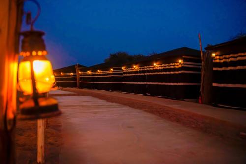 a street light with lights on a fence at night at Al Marmoom Oasis Luxury Tents and Bedouin Experience in Dubai