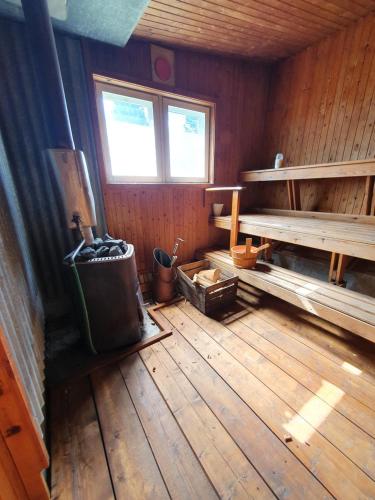 an empty room with a wooden floor and a bench at Camp Caroli Wooden Cabins in Jukkasjärvi