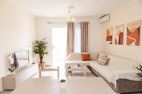 a white living room with a couch and a table at CAPTAIN'S RESIDENCE in Ksamil