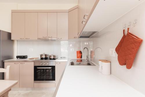 a kitchen with white cabinets and a sink at CAPTAIN'S RESIDENCE in Ksamil
