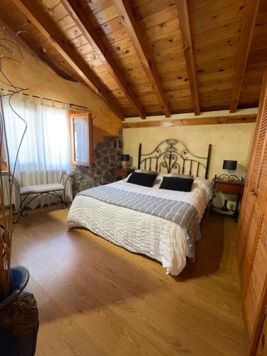 a bedroom with a bed in a room with wooden ceilings at Casa Obis in Muñeca