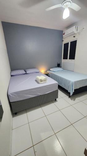 a bedroom with two beds and a blue wall at Apto 2 quartos Inteiro privativo Palmas TO in Palmas