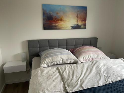 a bedroom with a bed with a painting on the wall at Ferienhaus Seepferdchen in Holnishof