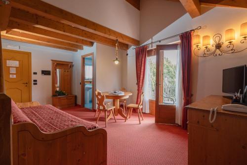 a bedroom with a bed and a table and a television at Gaarten Hotel Benessere Spa by Kleos Group Collection in Gallio