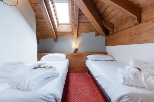 two beds in a small room with a window at Gaarten Hotel Benessere Spa by Kleos Group Collection in Gallio