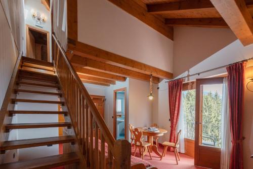 a staircase in a living room with a table and chairs at Gaarten Hotel Benessere Spa by Kleos Group Collection in Gallio