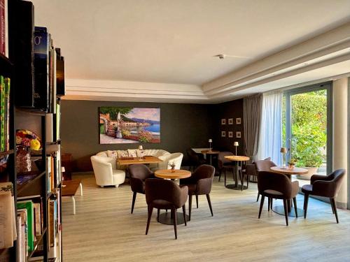 a living room with tables and chairs and a couch at Hotel Alfieri in Sirmione