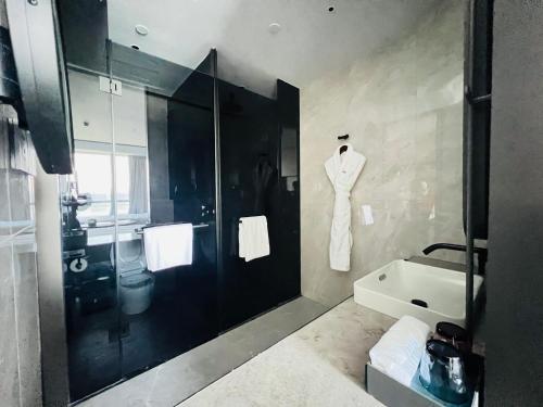 a bathroom with a shower and a robe hanging on the wall at Crowne Plaza Hangzhou Riverside by IHG in Hangzhou