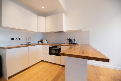 une cuisine avec des armoires blanches et un comptoir en bois dans l'établissement Seaview with Terrace, à Cannes