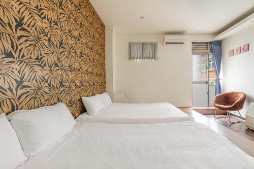 a bedroom with two beds and a wall mural at 桔子小屋 in Luodong
