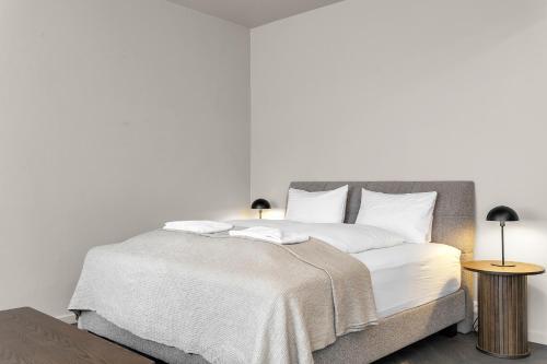 a bedroom with a bed with white sheets and two lamps at The Swan House by Heimaleiga in Reykjavík