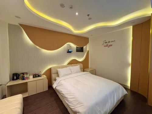 a bedroom with a white bed and a white couch at Star Night Hotel and Apartment in Hanoi