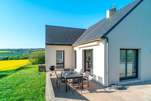 a patio with a table and chairs in front of a house at Dreon Ker - Calme à deux pas du bourg in Plomodiern