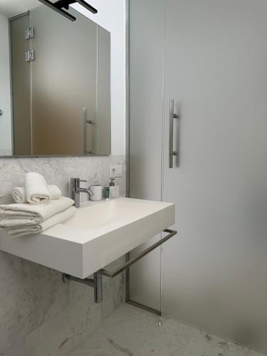 a bathroom with a white sink and a mirror at BeachVibe in Puerto Naos