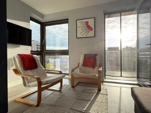 a living room with two chairs and a large window at William place in Wembley - Close to Wembley Stadium & Wembley Arena, 12 mins away from Central London by train in London