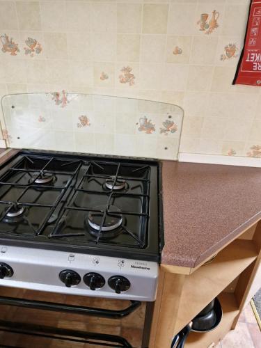 a stove top oven in a kitchen next to a counter at Beachside caravan, Family-friendly, WiFi in Ingoldmells
