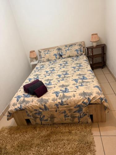 un letto in una camera da letto con una coperta e un tappeto di Família Moreira a Travassos