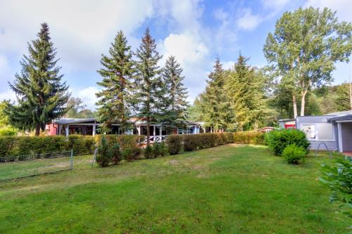 a yard in front of a house with trees at Korswandt, Ostseebungalow in Korswandt