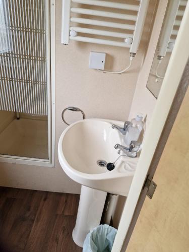 a bathroom with a sink and a mirror at Beachside caravan, Family-friendly, WiFi in Ingoldmells