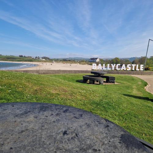 a park with a bench on the beach at Beach View Ballycastle Escape in Ballycastle