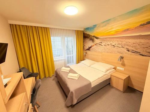 a bedroom with a bed and a painting of a beach at Hotel La Siesta & Medical Spa in Jastrzębia Góra